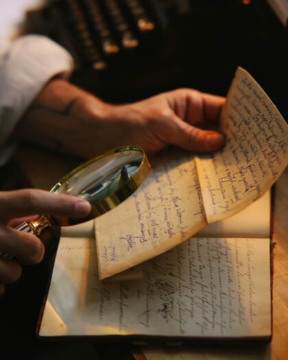 hand holding magnifying glass to written letter